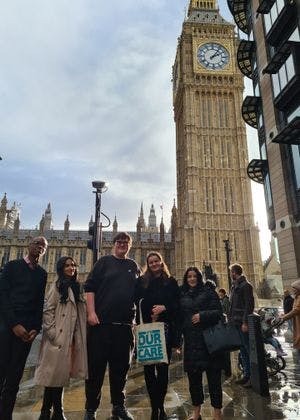 A group of five young people standing in front of Big Ben