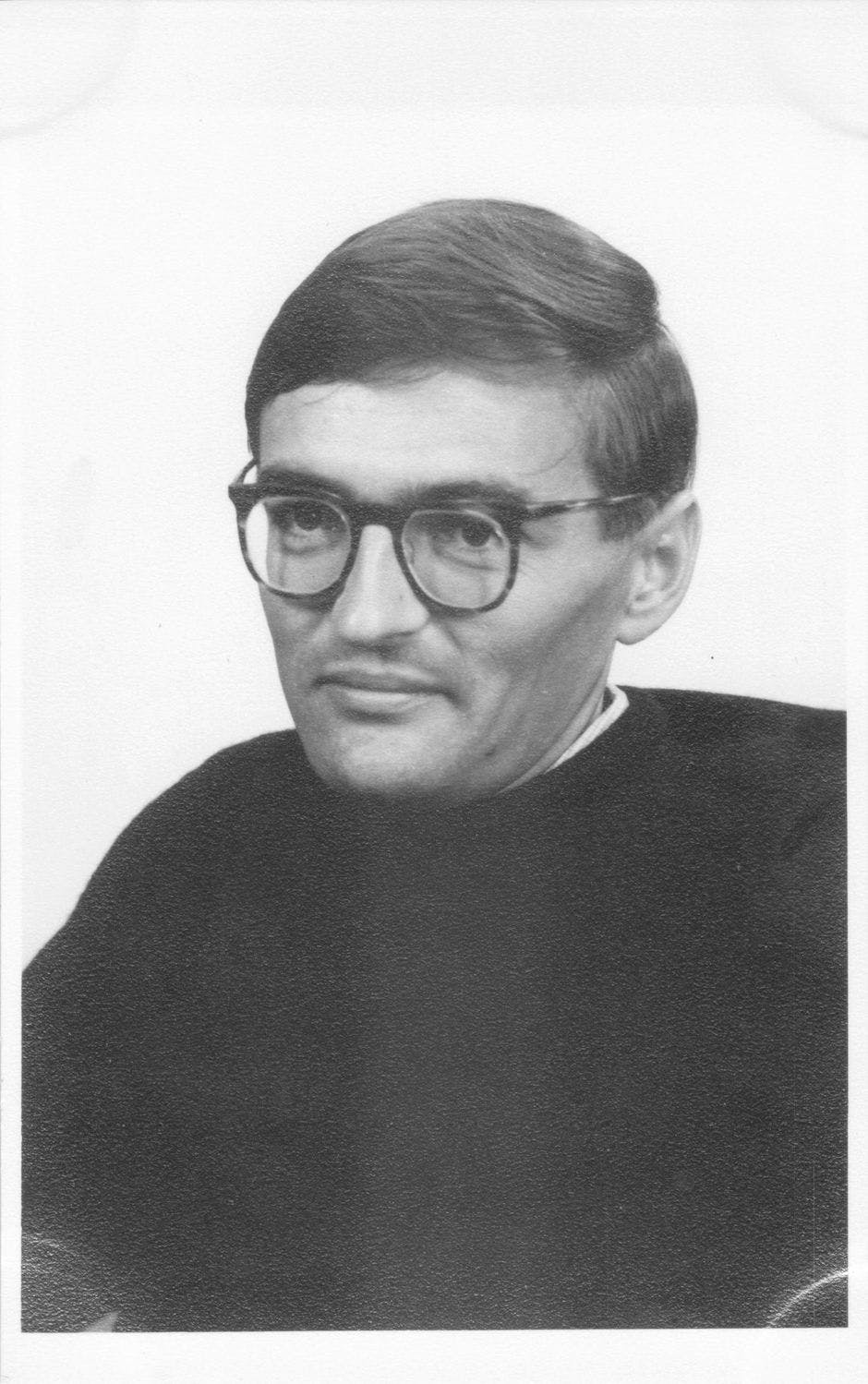 A black and white photo portrait of a man with glasses